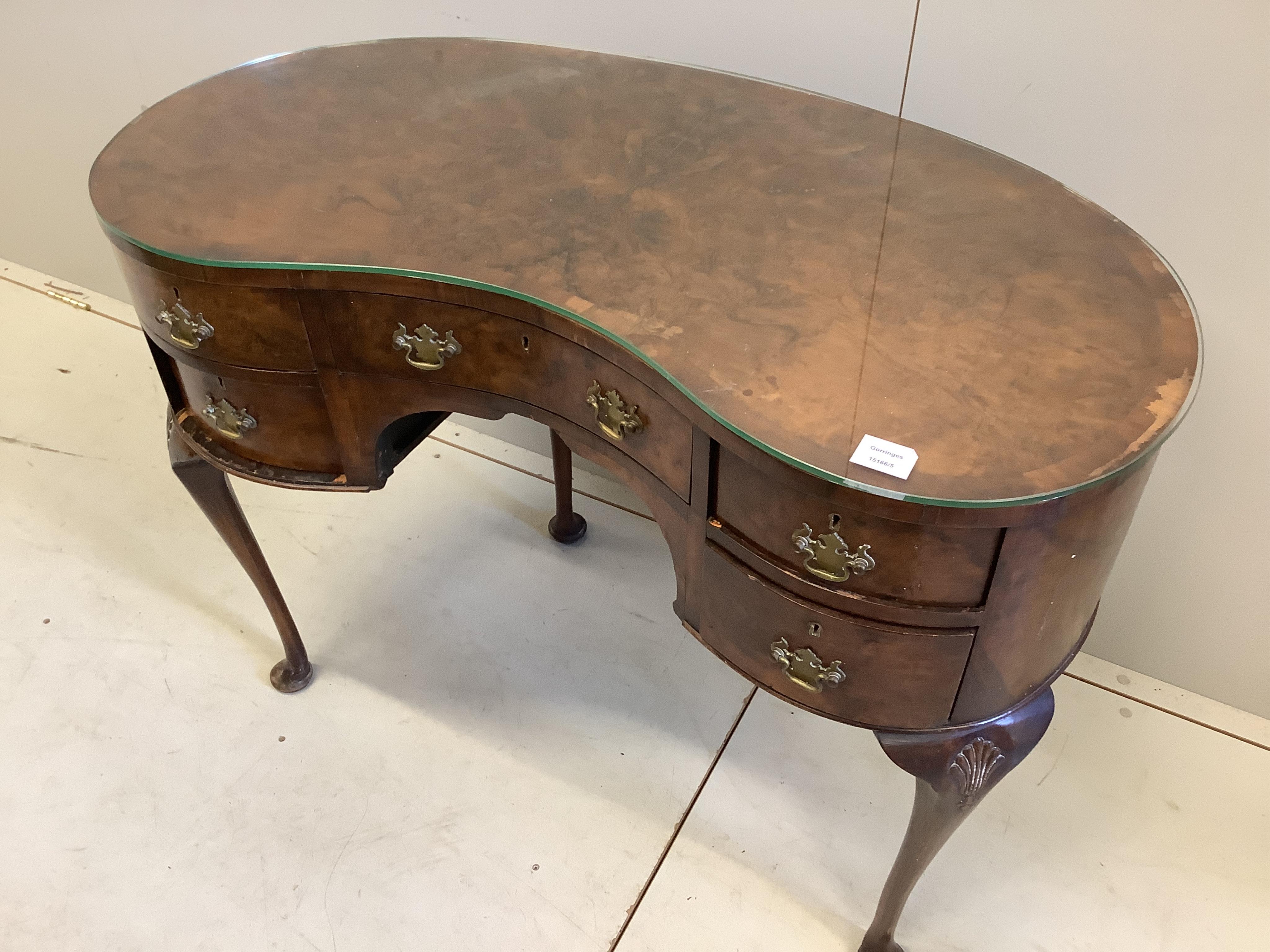 A Queen Anne Revival walnut kidney shaped kneehole dressing table, width 101cm, depth 56cm, height 76cm. Condition - fair